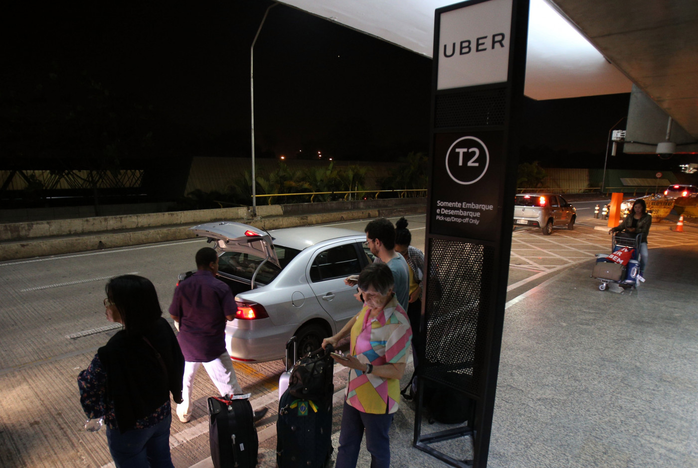 Pessoas aguardam por Uber no terminal de Guarulhos