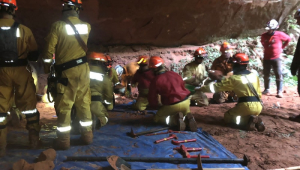 Bombeiros trabalham dentro da gruta para resgatar colegas soterrados