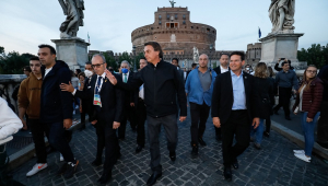 À frente da comitiva brasileira, Jair Bolsonaro acena na Praça de São Pedro, no Vaticano, com a catedral ao fundo