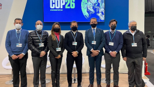 Perfilado com outras seis autoridades que participaram com ele de painel sobre mudanças climáticas (três à sua esquerda e três à sua direita), João Doria posa para foto em frente a uma tela com o símbolo da COP26