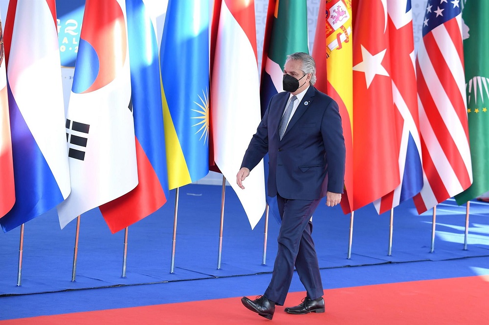O presidente da Argentina, Alberto Fernández, passa por um corredor com as bandeiras de todos os países