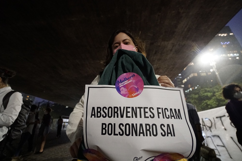 No vão livre do Masp, Samia Bonfim posa de máscara com um cartaz escrito 
