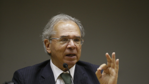 Ministro da Economia, Paulo Gedes fala com a mão levantada