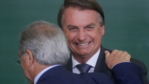 Presidente Jair Bolsonaro sorri enquanto recebe apoio do ministro Paulo Guedes