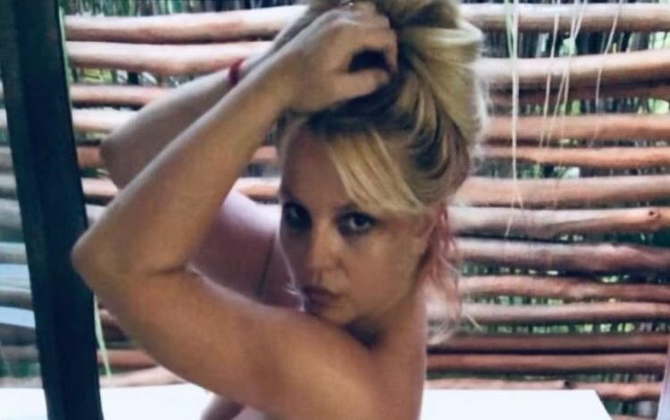 Britney Spears segurando o cabelo com as mãos