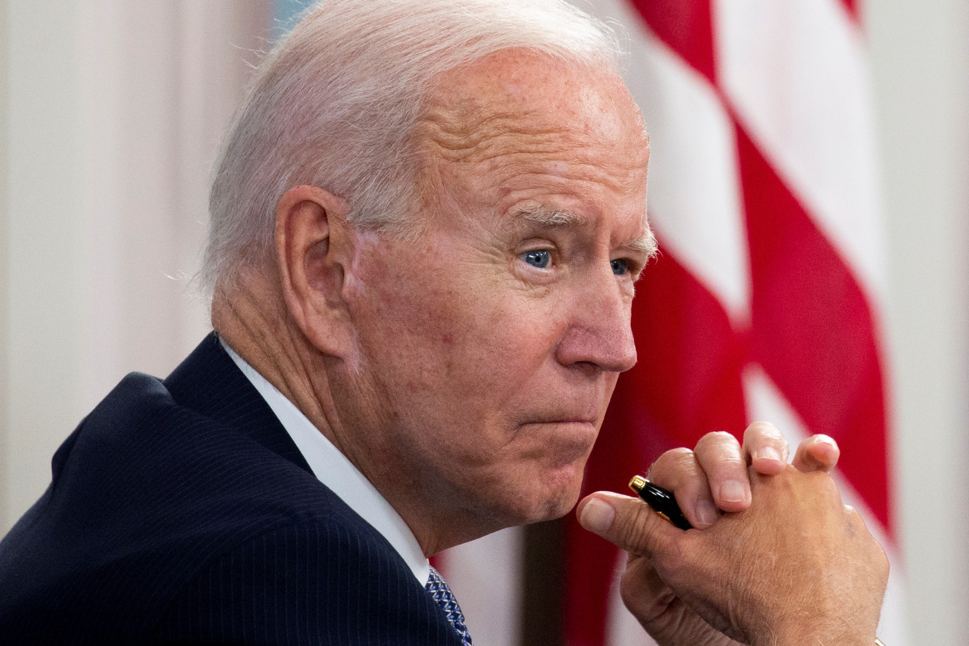Joe Biden apoia a mão no queixo de perfil