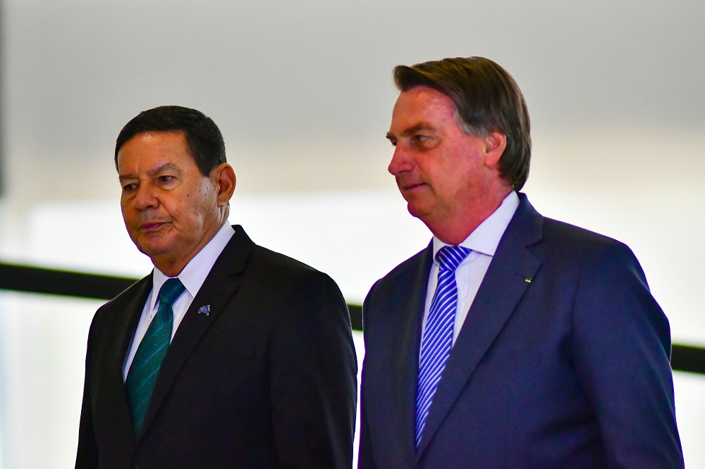 Vestidos em trajes socais, Hamilton Mourão (à esquerda) e Bolsonaro caminham lado a lado no Palácio do Planalto