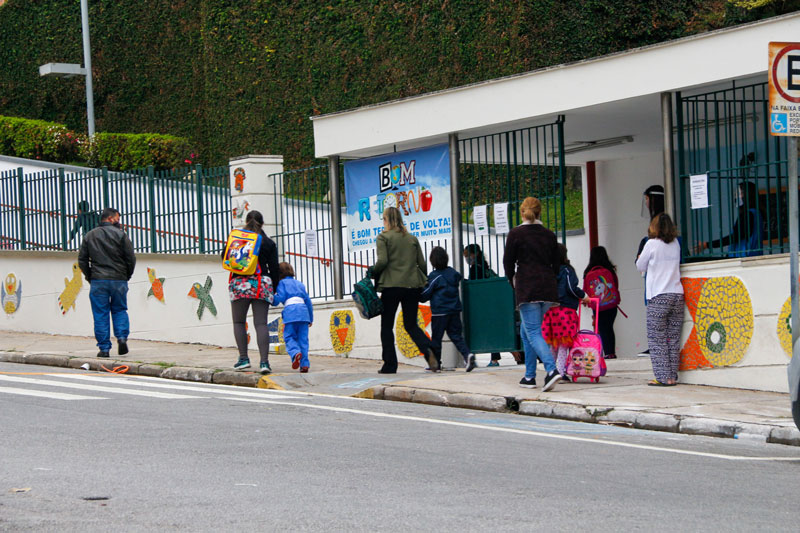 Pais e alunos em frente a uam escola