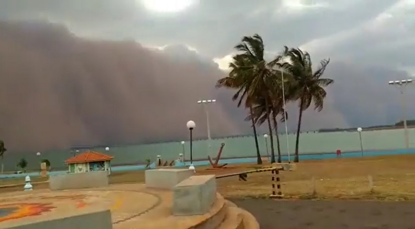 nuvem de poeira se aproximando de cidade