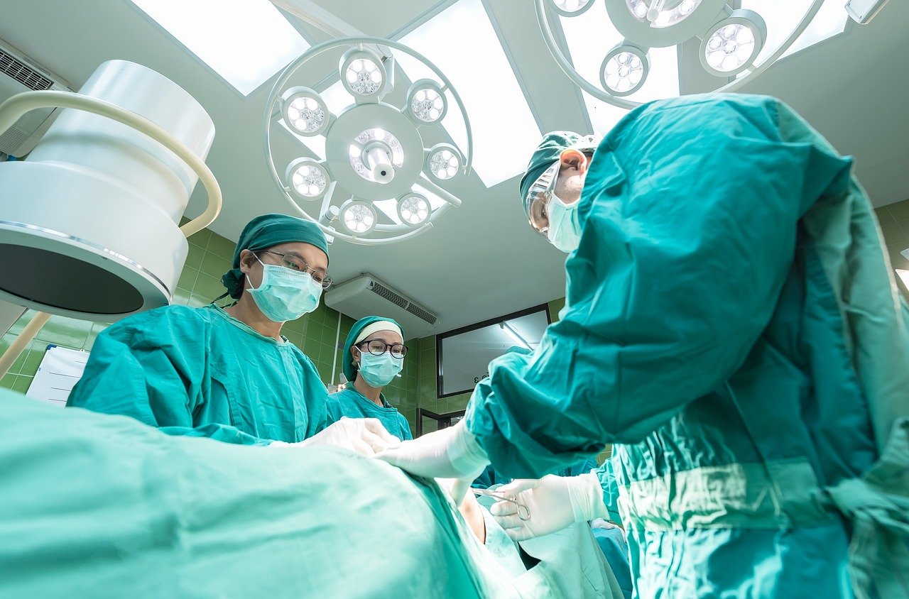 Imagem de três médicos realizando uma cirurgia