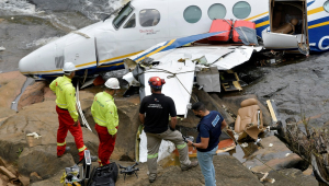 Policias e outras autoridades checam os destroços do avião