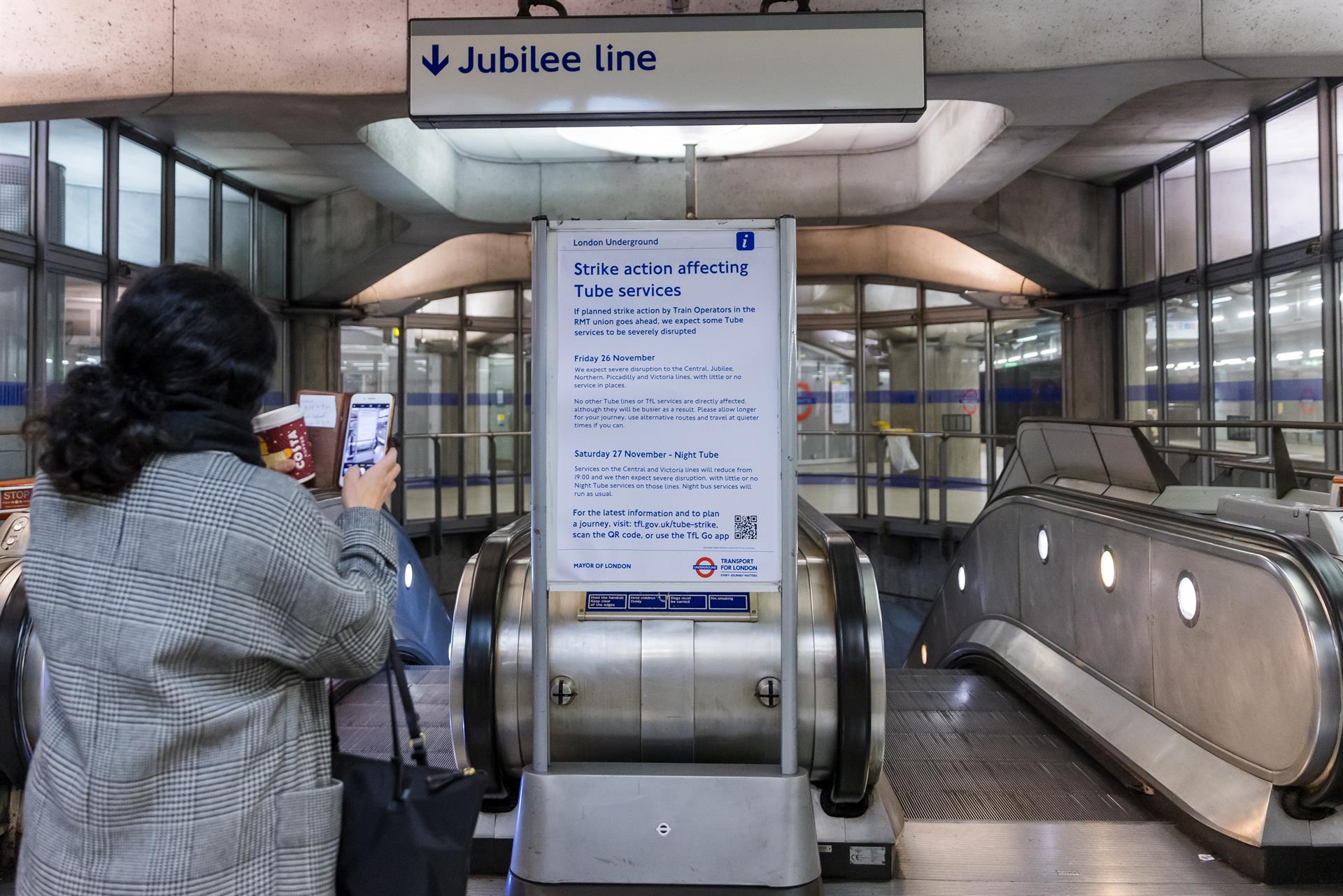 pessoas olhando aviso informando sobre paralisação do metrô de londres