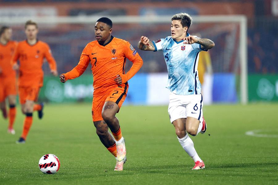 Jogador holandês Bergwijn conduz a bola enquanto é marcado por adversário da Noruega