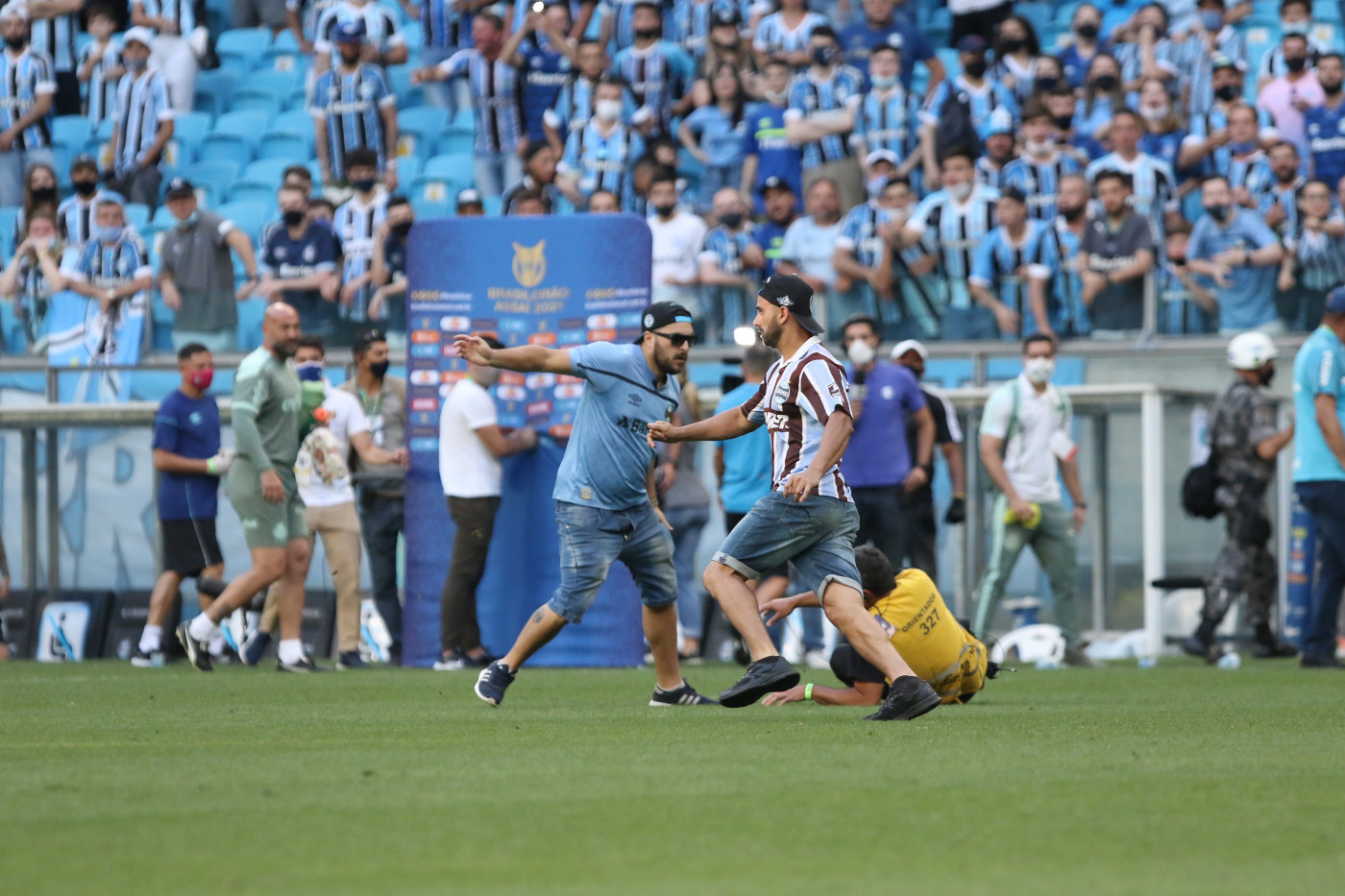 Torcedores do Grêmio invadindo o gramado do estádio após partida contra o Palmeiras