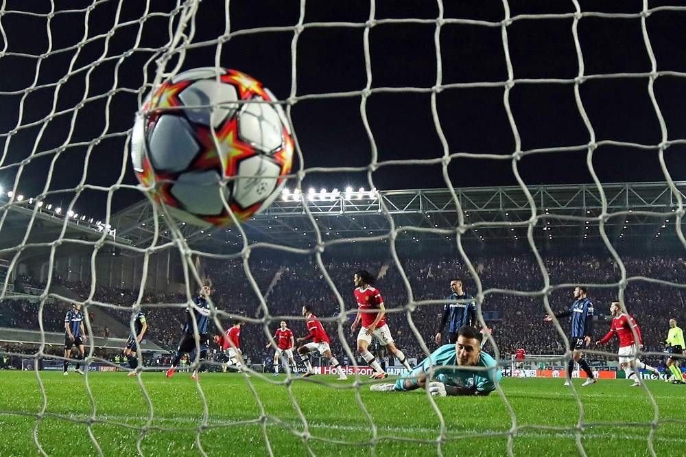 Bola balança a rede após chute de Cristiano, que comemora ao fundo com os companheiros, enquanto o goleiro da Atalanta, caído, olha para o gol,