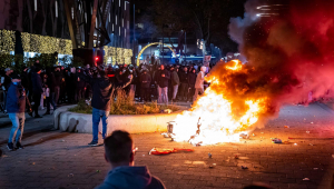 pessoas tocando fogo em pneus durante protesto na Holanda