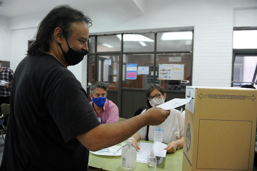homem colocando voto em urna