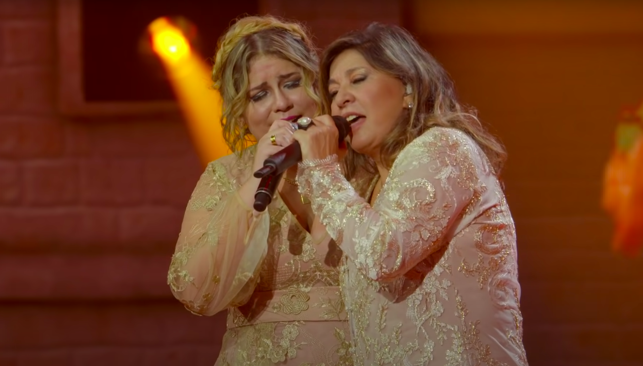 Cantora Marília Mendonça e Roberta Miranda cantando abraçadas