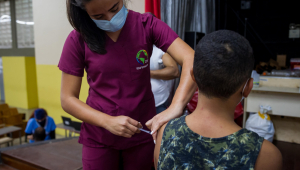 Enfermeira aplica vacina em criança na Venezuela
