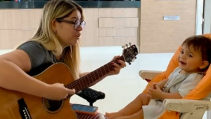 Marília Mendonça tocando violão para o filho
