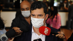De máscara, com o microfone do Jovem Pan à sua frente (do lado esquerdo), Sergio Moro dá entrevista a jornalistas