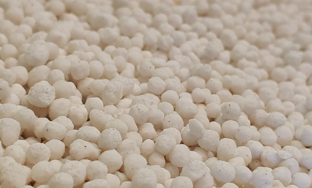 Imagem composta por pequenas bolinhas brancas, que nada mais é do que fertilizante nitrogenado granulado