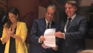 O presidente Jair Bolsonaro ao lado de Valdemar da Costa, presidente do PL, segurando o papel que firma a sua filiação à legenda