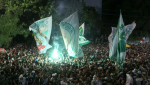 Torcedores do Palmeiras fazem festa com bandeiras na rua em frente ao CT do clube