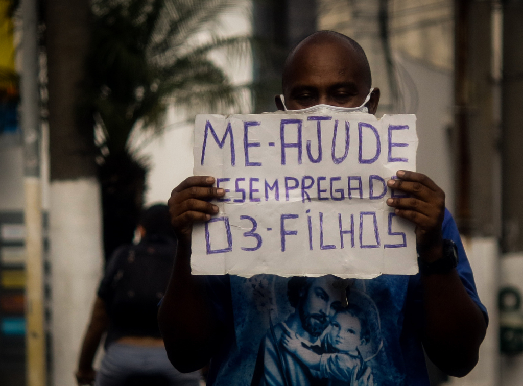 Homem mostra placa pedindo ajuda