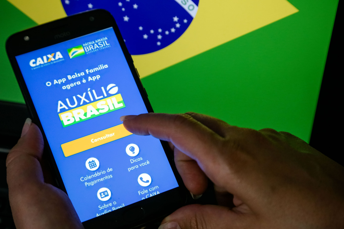 Pessoa mexe em aplicativo do Auxílio Brasil