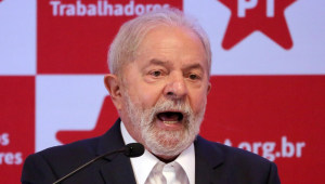 Em frente a um banner do PT, Lula fala ao microfone