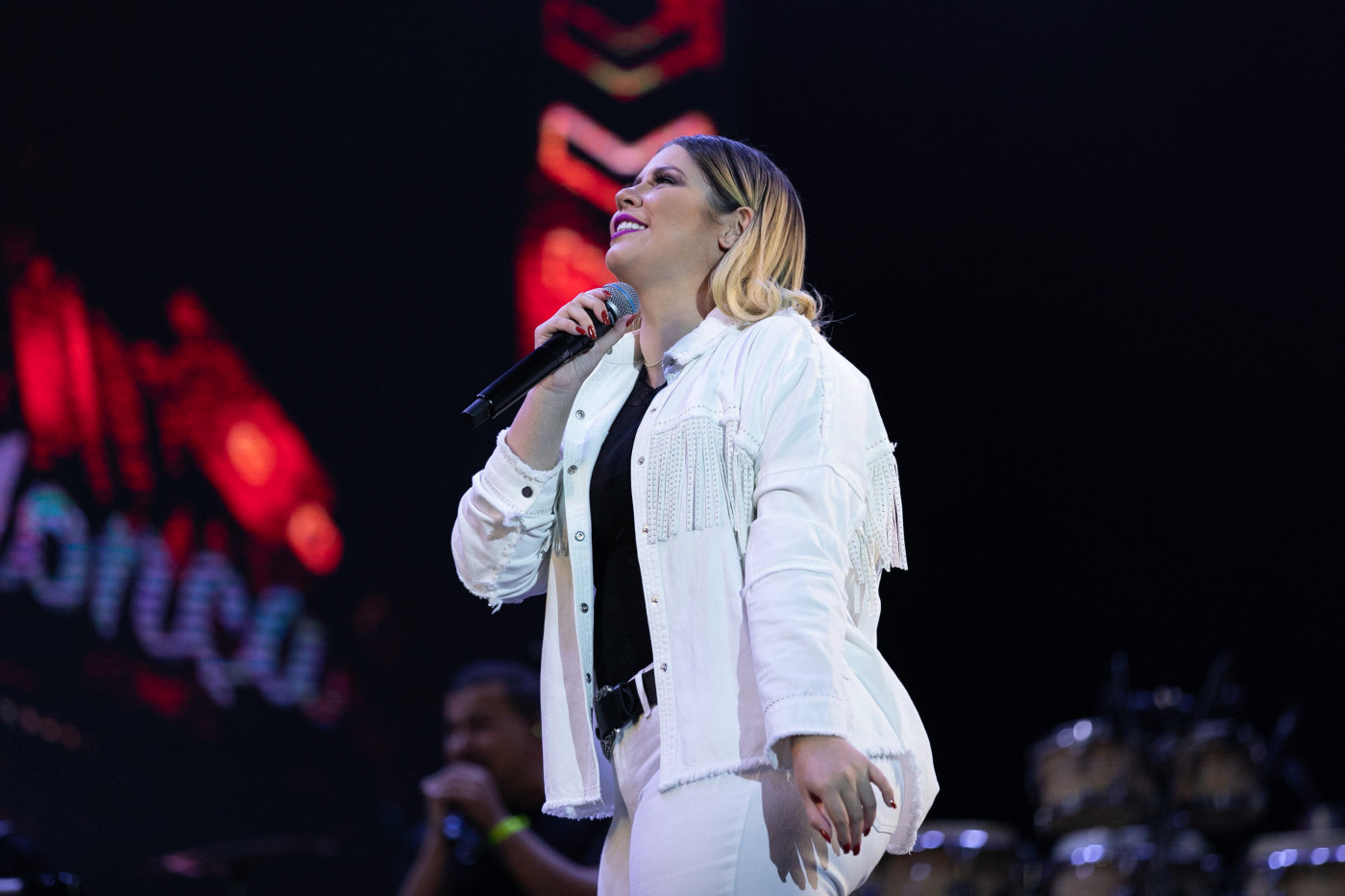 A cantora Marília Mendonça olhando para o alto enquanto canta em show no Rio de Janeiro