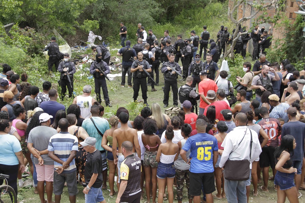 Moradores de São Gonçalo observam policiais do Bope retirarem corpos de terreno