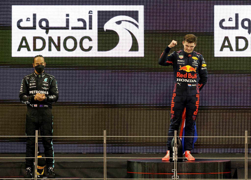 No lugar mais alto do pódio, Verstappen comemora, enquanto Hamilton, segundo colocado, aplaude