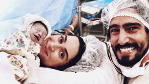 Thaila Ayala na mesa de parto segurando o seu filho Francisco ao lado de Renato Goés