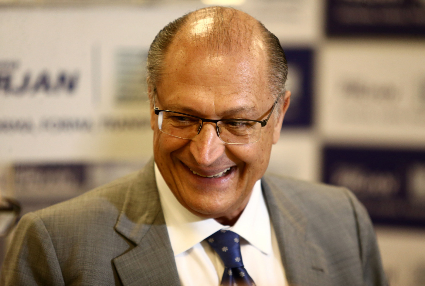 Geraldo Alckmin de terno cinza sorrindo