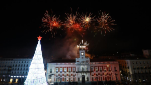 Fogos de artifício explodem acima de prédios e de árvore de natal iluminada em Madri, capital da Espanha