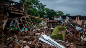 Pessoas tentam resgatar seus pertences em casas destruídas pelas enchentes provocadas pelas chuvas, na cidade de Itambé, no estado da Bahia
