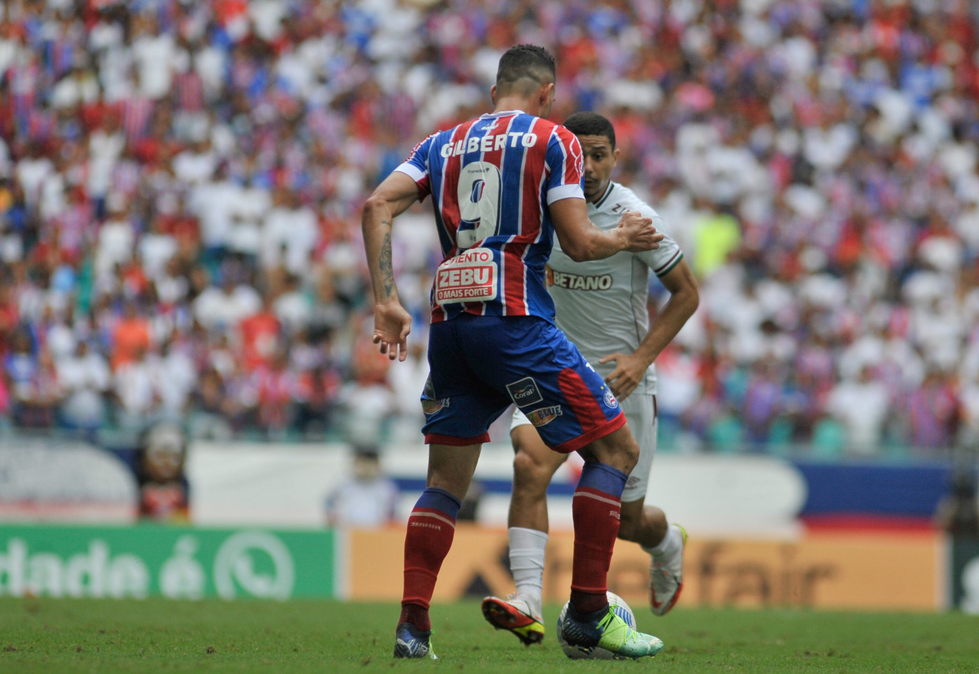 Gilberto domina a bola enquanto jogador do Fluminense chega para marcá-lo