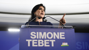 Mulher em fala em frente a dois microfones; placa à frente diz 'Simone Tebet, uma nova esperança para o Brasil'