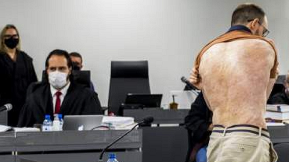 Homem branco mostra queimaduras nas costas durante audiência no Tribunal de Justiça do Rio Grande do Sul