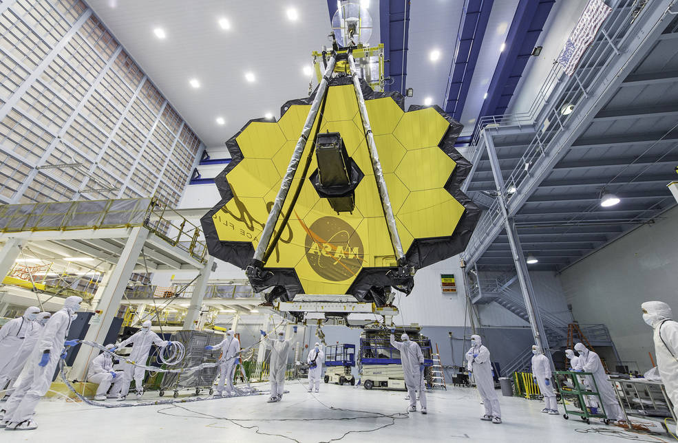 Os técnicos da NASA levantam o telescópio James Webb, usando um guindaste