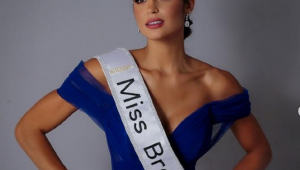 Carol Teixeira, miss Brasil, com vestido azul, faixa e coroa