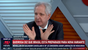 O comentarista Augusto Nunes aproxima s mãos e gesticula com elas espalmadas enquanto comenta no estúdio do programa Os Pingos nos Is