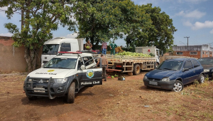Caminhão com melancias e viatura da Polícia Civil estacionados em estrada de terra