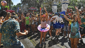 Foliões são borrifados com água em uma festa de rua durante o bloco anual 'Ceu Na Terra', no Rio de Janeiro
