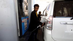 Um atendente bombeia combustível em um ônibus em um posto de gasolina em meio a uma grave escassez de combustível no Iêmen