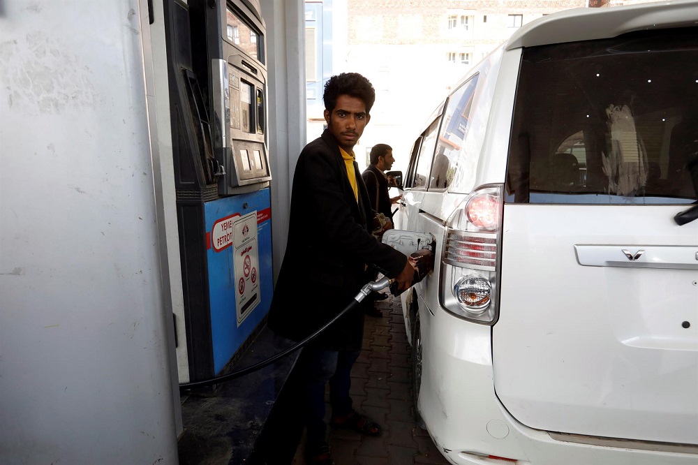 Um atendente bombeia combustível em um ônibus em um posto de gasolina em meio a uma grave escassez de combustível no Iêmen