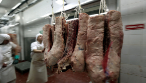 Um açougueiro arruma peças de carne bovina em um açougue em San Fernando, Argentina