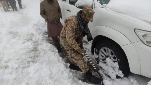 Soldado tenta desatolar carro após tempestade de neve